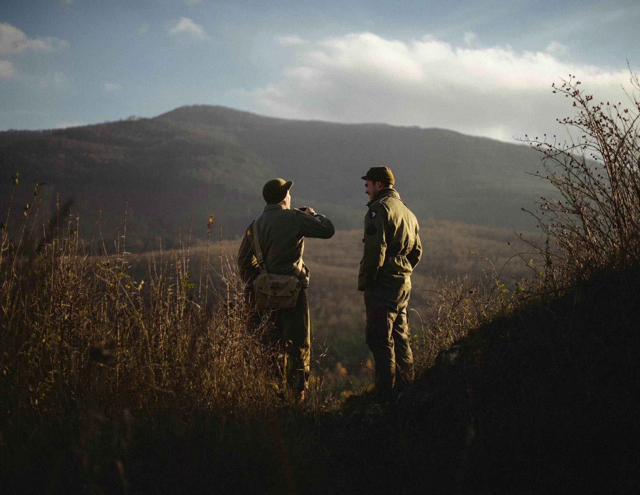 Two hunters glassing a mountain ridge at golden hour
